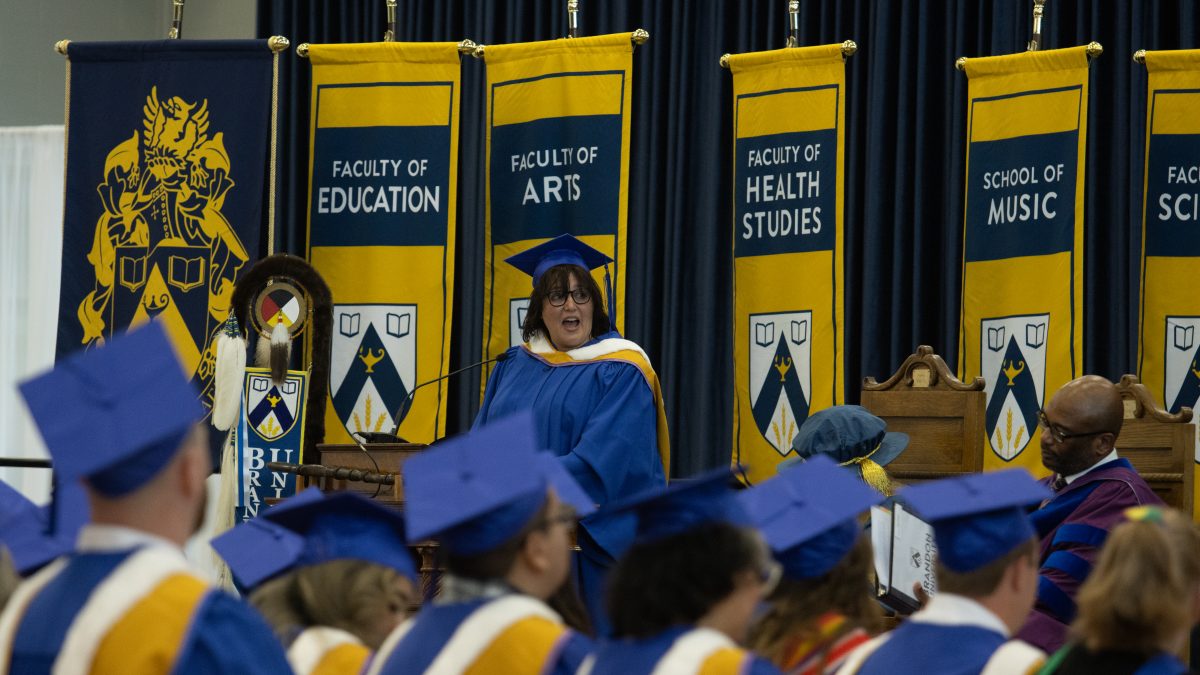 A graduating student speaks from the Convocation stage.