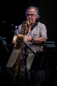A man plays a saxophone into a microphone