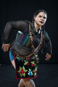 A person dances in ceremonial Indigenous dress