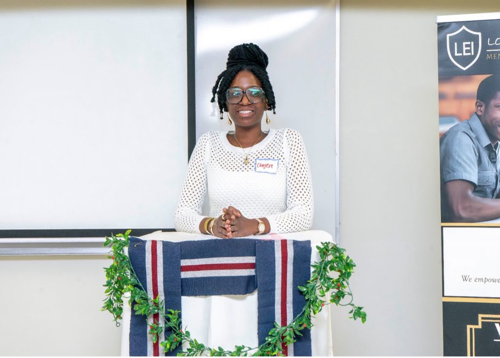 A woman smiles while standing at a lectern