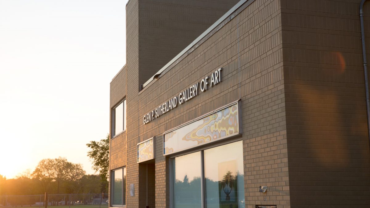 A brick building is seen in the glow of a sunrise