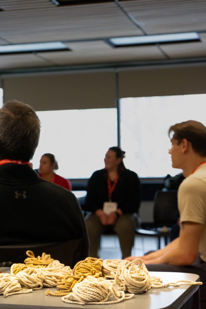 A group of students on chairs take in a presentation.