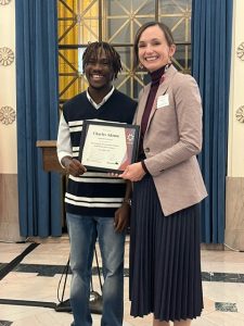 A man receives a certificate from a woman. Both are smiling.