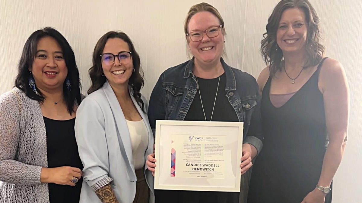 Four women pose with a certificate that one of them has won.