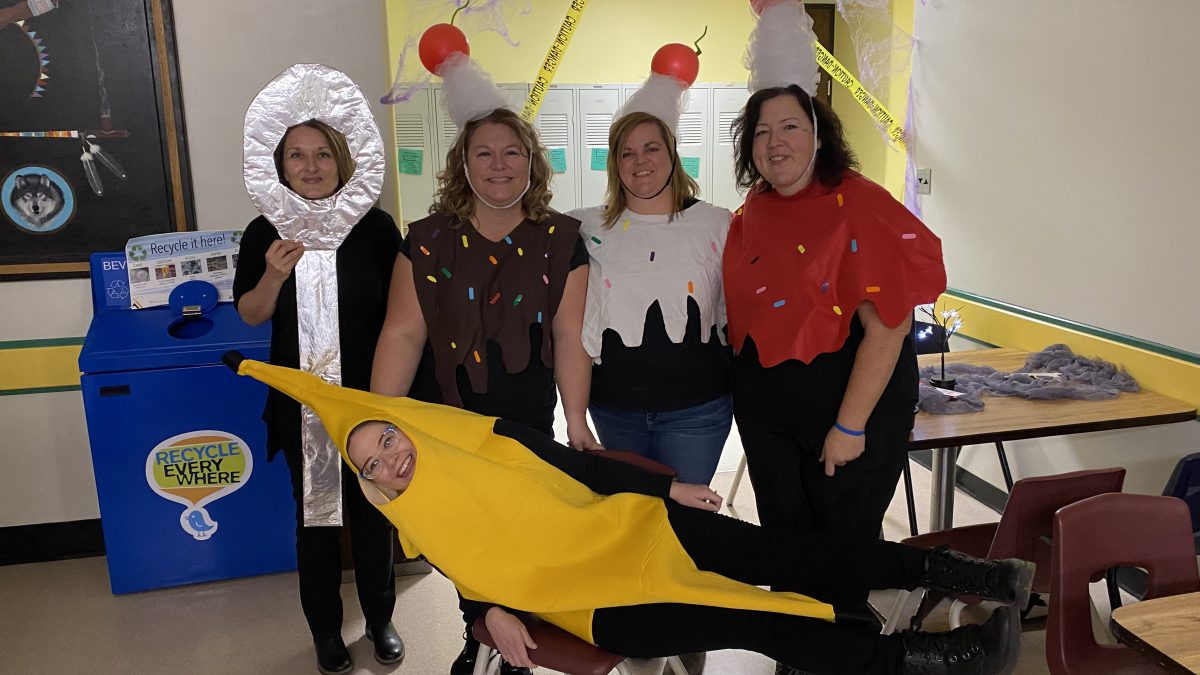 A woman dressed as a banana lies in front of three women dressed as ice cream and one dressed as a spoon