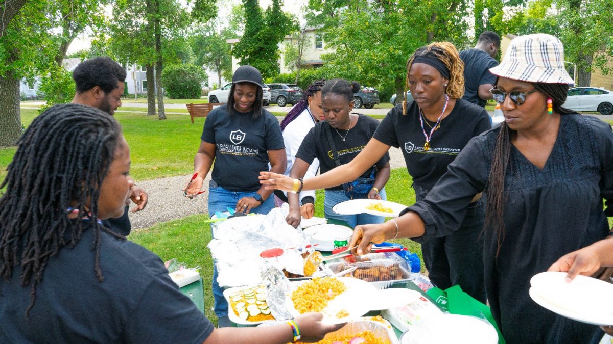 A group of students help themselves to a picnic meal.